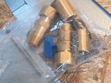 a bunch of brass fittings on a piece of plywood
