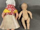 two dolls that are next to each other on a table