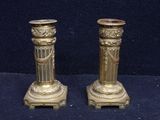 pair of antique brass candlesticks on a blue background
