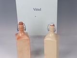 two small bottles of perfume sitting next to each other on a table