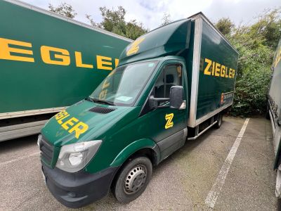 un camion de livraison vert garé sur un parking