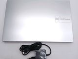a silver laptop with a charger on the side of it