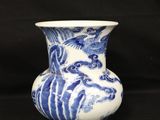 a blue and white vase sitting on a black surface