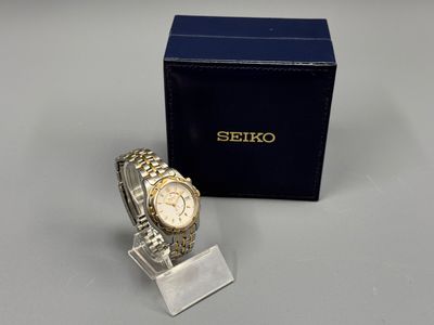 a close up of a watch on a stand next to a box