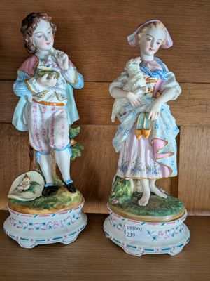 deux figurines représentant un garçon et une fille, posées sur une étagère