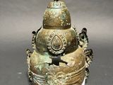an old bronze urn with a bird on top of it