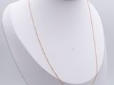 a white mannequin with a gold chain on a white mannequin