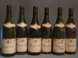 six bouteilles de vin sont alignées sur une table