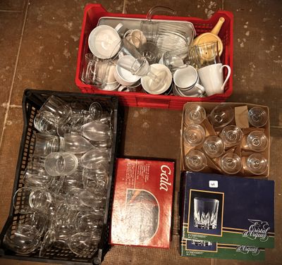 a basket full of empty dishes and cups on the floor
