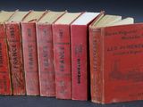 several red books are lined up on a black surface