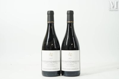 deux bouteilles de vin rouge posées sur une table blanche