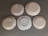 four white plates are arranged in a circle on a table
