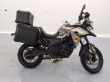 a motorcycle parked in a room with a suitcase on the back