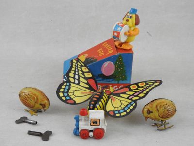 un petit train sur lequel est dessiné un papillon, à côté d'une boîte d'œufs