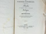 an old book opened on top of a wooden table