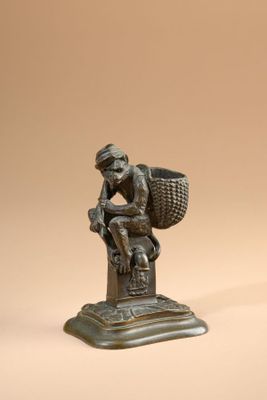 bronze figurine of a man with a basket on his head