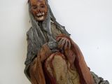 une statue représentant un homme à la longue barbe tenant un sac