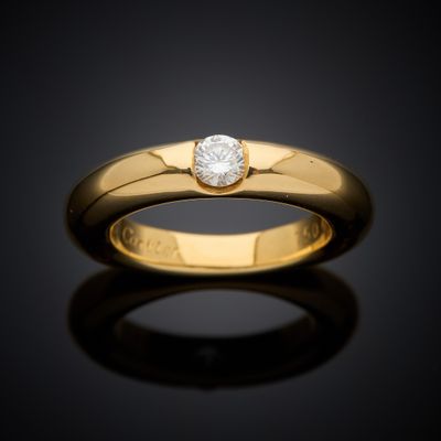 a yellow gold ring with a single diamond in the center