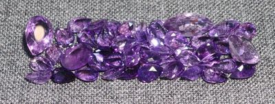 de très jolis cristaux violets posés sur un tissu gris