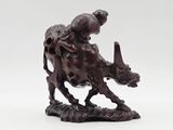 a statue of a man riding a bull on a white surface