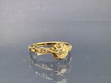 une photo d'une bague en or posée sur une table en verre
