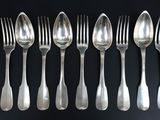 beaucoup de cuillères et de fourchettes en argent sur une table