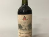 une vieille bouteille de vin posée sur une table blanche
