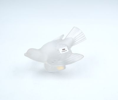 a glass bird that is sitting on a white surface
