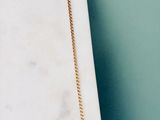un collier muni d'une chaîne en or, posé sur une dalle de marbre