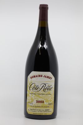 an old bottle of wine sitting on top of a white table