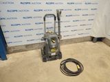 une pompe à pression électrique posée au sol devant un mur