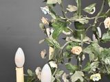 a chandelier with flowers and candles hanging from it