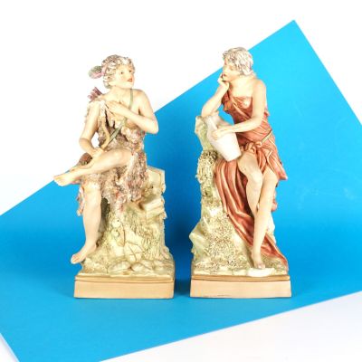 deux figurines d'un homme et d'une femme assis sur un rocher
