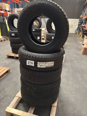 tires are stacked on pallets in a warehouse with pallets in the background