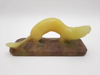 une photo d'une sculpture représentant un ver posée sur un socle en bois