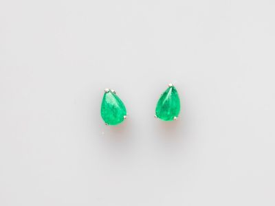 une paire de boucles d'oreilles en émeraude sur fond blanc