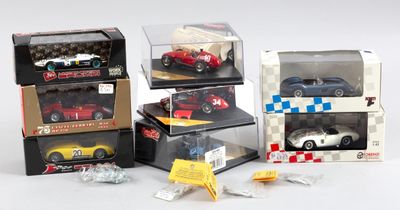 Plusieurs petites voitures sont exposées dans une vitrine posée sur une surface blanche