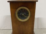 an image of a wooden clock with a black face and gold trim