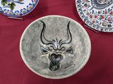 un bol orné d'une tête de taureau, posé sur une table