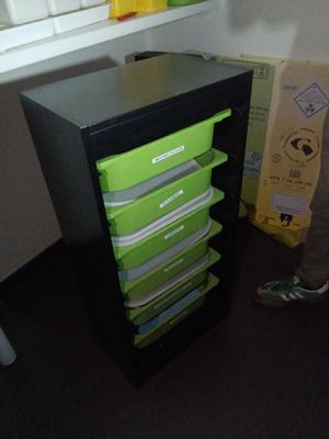 un homme debout devant un classeur noir et vert