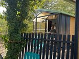 une chaise verte posée devant une clôture noire
