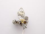 sterling silver broochle with yellow and brown stones on a white background