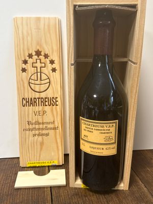 La bouteille de vin se trouve dans une caisse en bois posée sur la table.
