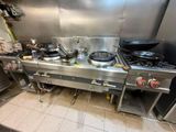 une cuisine équipée d'une cuisinière, d'une plaque de cuisson et d'autres appareils électroménagers