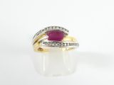 a close up of a gold ring with a ruby stone and diamonds