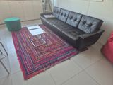 a black leather couch sitting in the middle of a living room