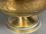 a large metal bowl with a lid on a table