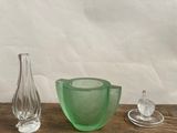 un saladier en verre vert et un vase en verre posés sur une table en bois
