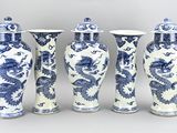 four blue and white vases with dragon designs on them