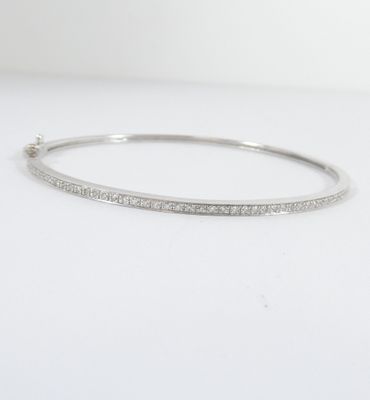 un gros plan d'un bracelet à maillons en diamant posé sur une surface blanche